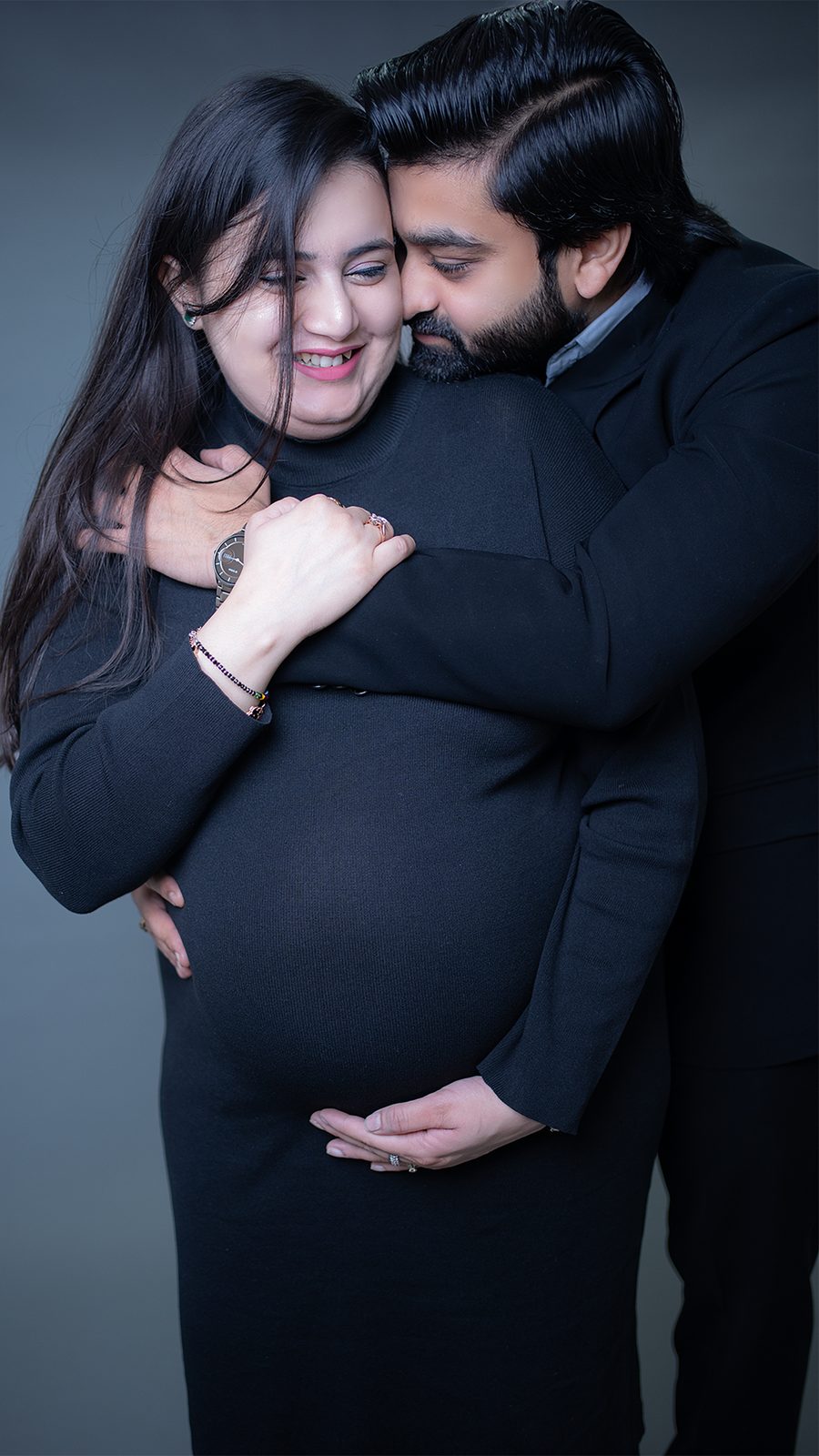 Joyful maternity couple portrait in black outfits — Vogue Productions