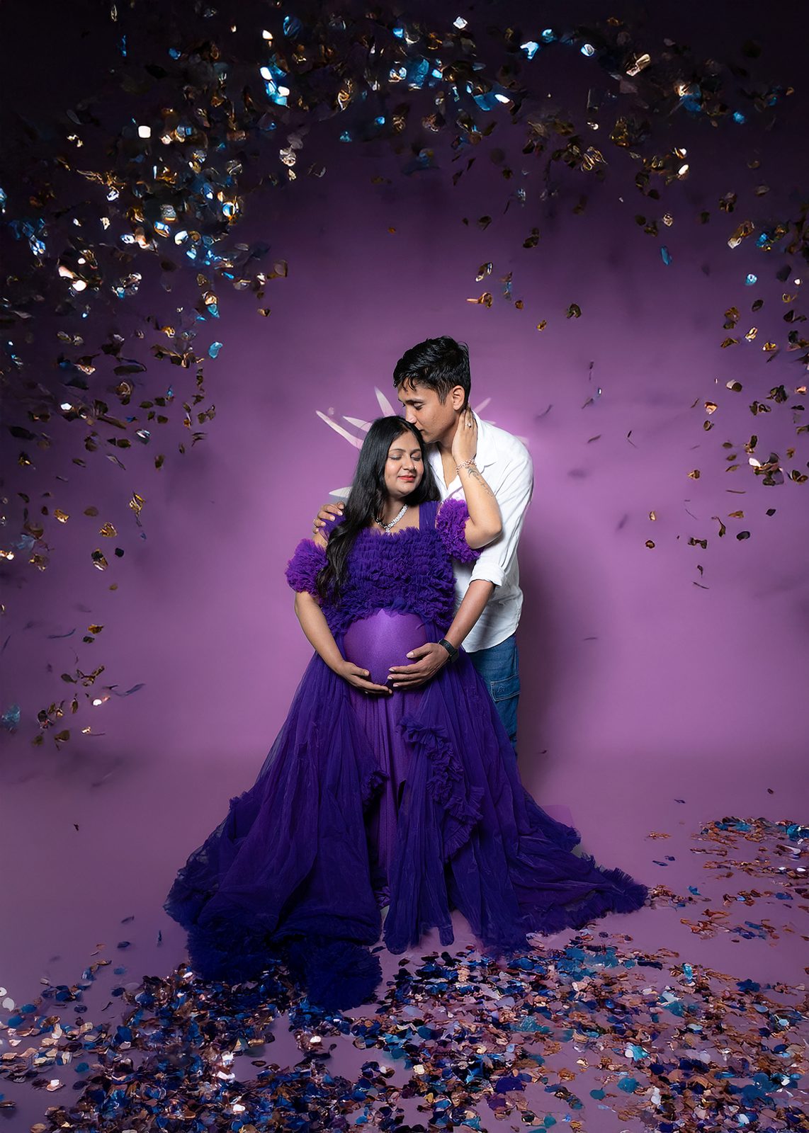 Purple gown maternity couple shoot with golden confetti studio